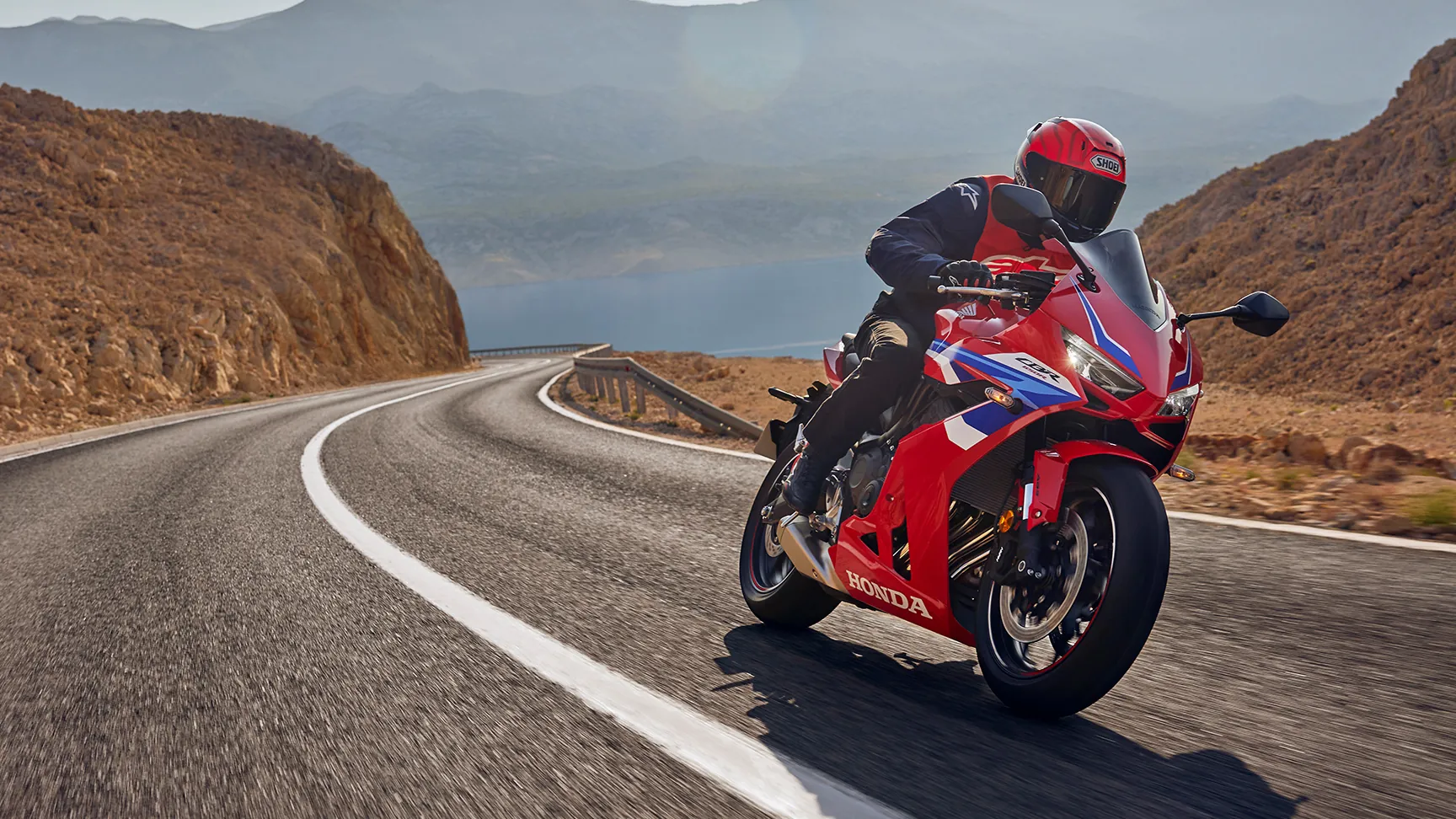 Motard sur une Honda sportive rouge dans un virage, garage moto FNR 91 à Ris-Orangis
