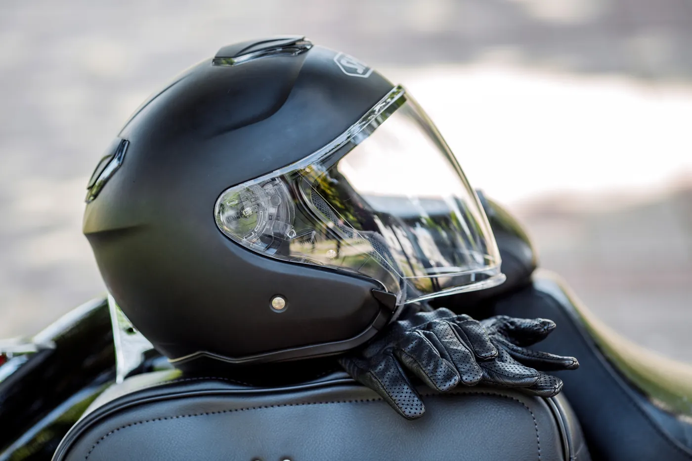 Casque de moto et gants posés sur une selle, équipements vendus chez FNR 91