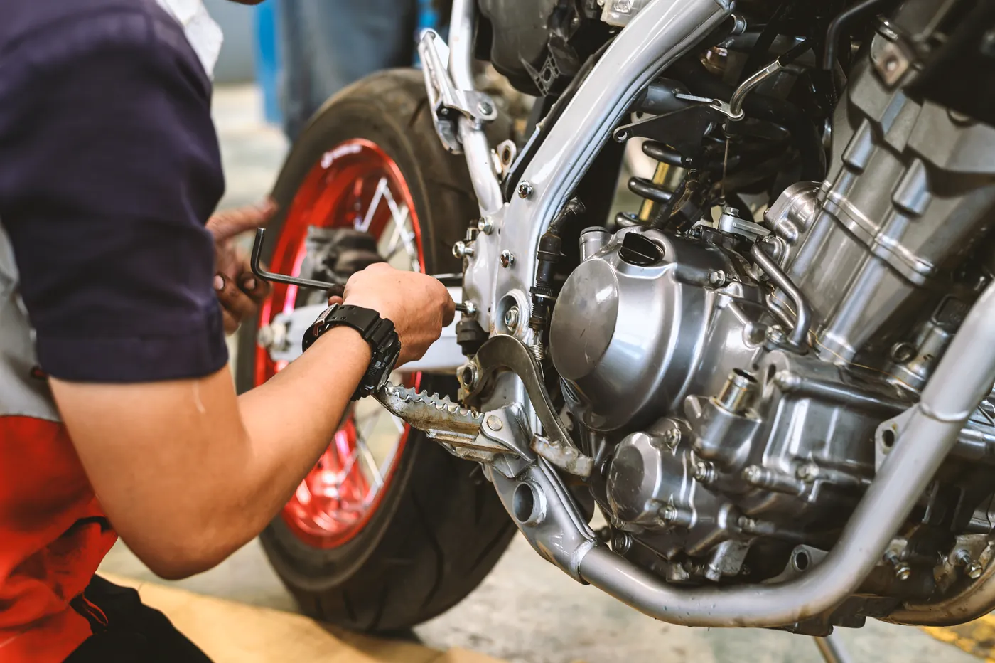 Mécanicien réparant le moteur d’une moto dans l’atelier FNR 91